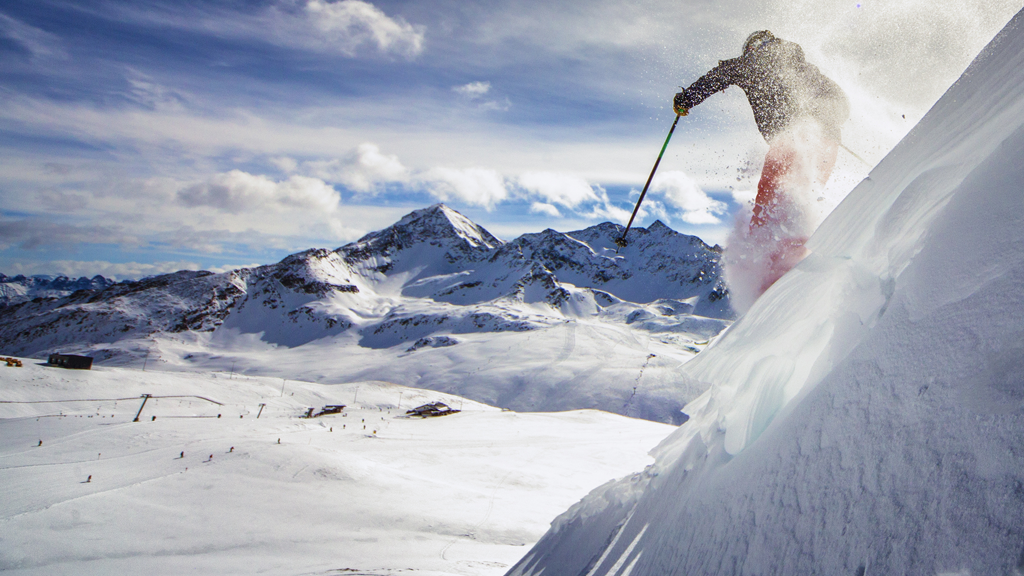 Person der står på ski ned ad bakke