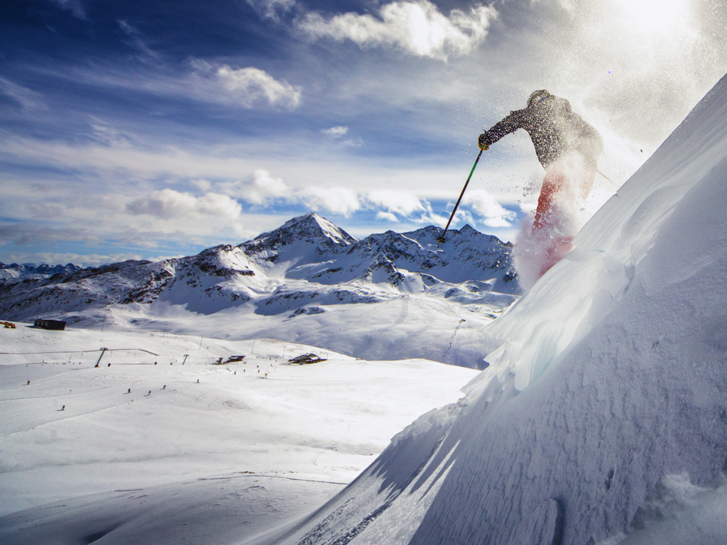 Person der står på ski ned ad bakke