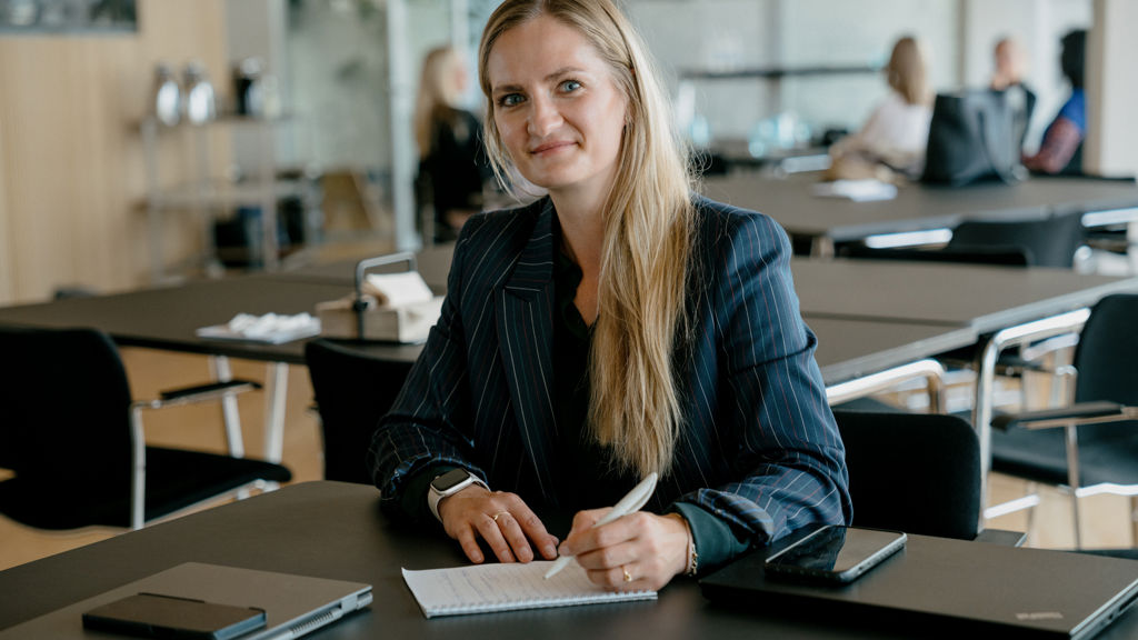 en kvinde kigger op fra sin notesblok