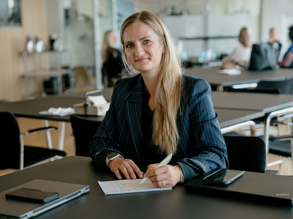 en kvinde kigger op fra sin notesblok