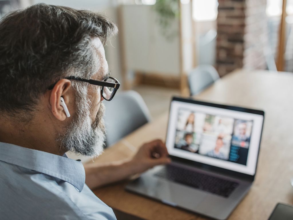 mand har et online møde og arbejder hjemmefra
