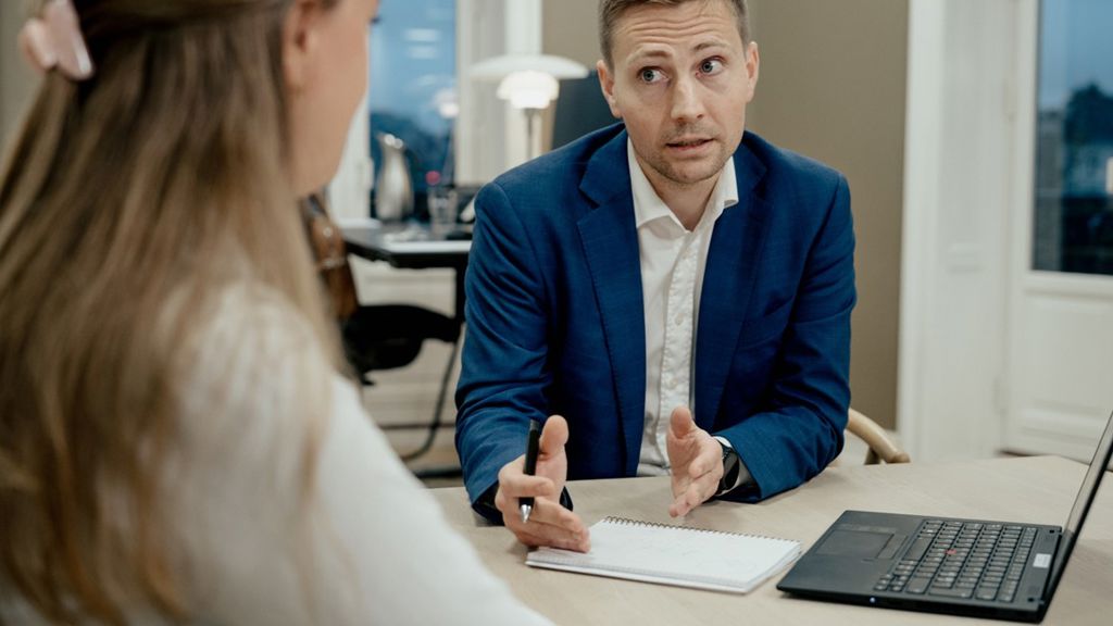 mand forklarer noget til en kvinde i et mødelokale