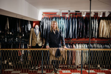 David Krarup i sin butik foran rækker med jakker.
