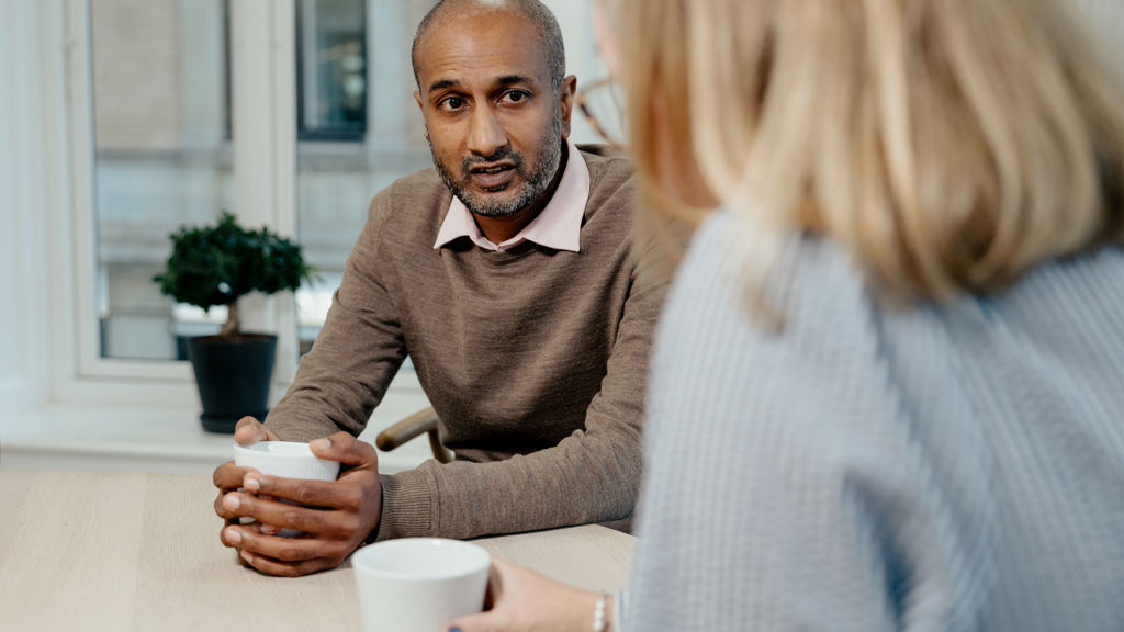 en mand og en kvinde snakker sammen på et kontor