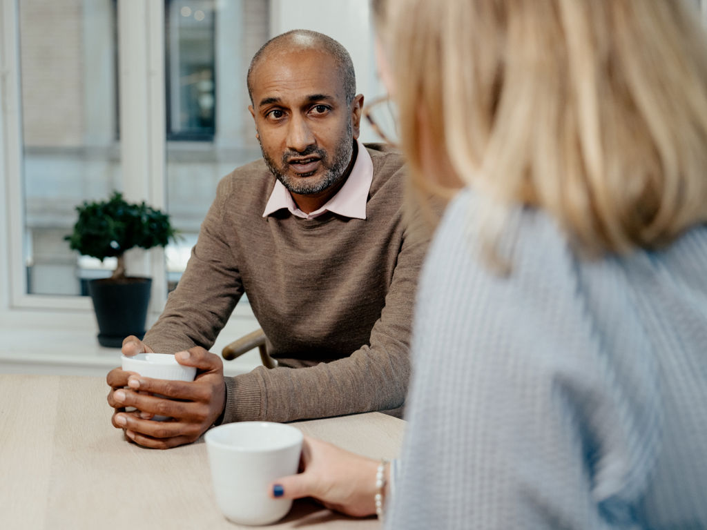 en mand og en kvinde snakker sammen på et kontor