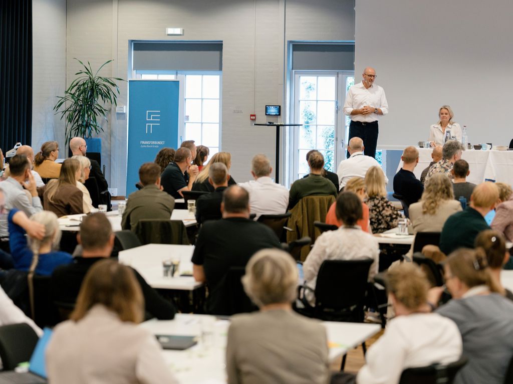 Sal med mennesker der lytter til en person der taler fra podiet