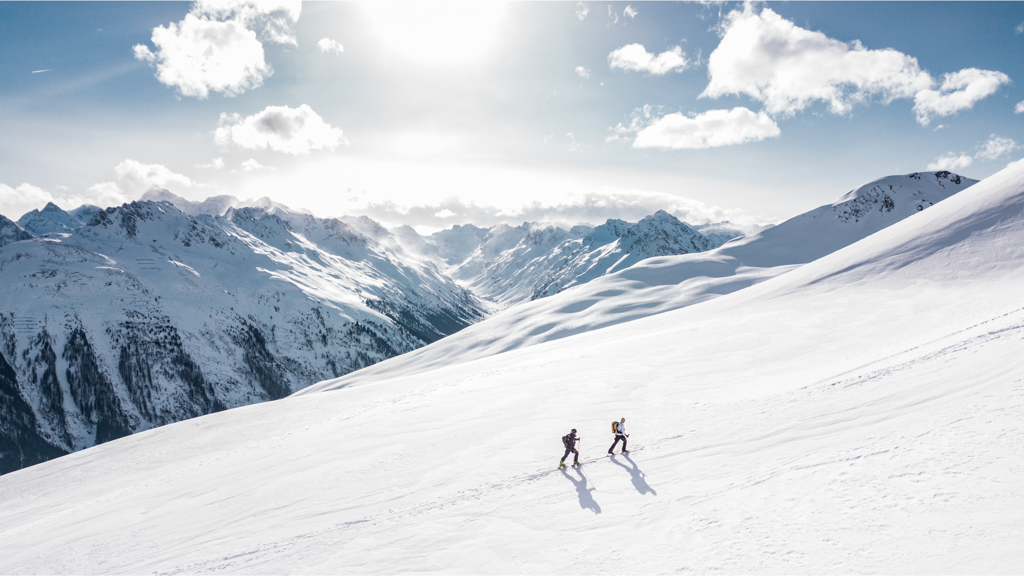 To personer på ski på vej op ad bakke