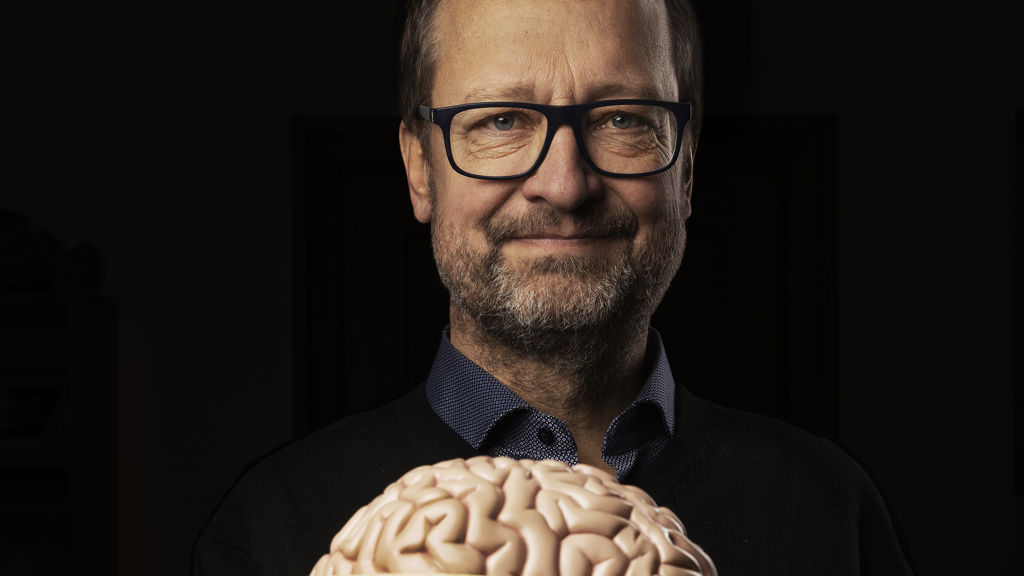 Troels Kjær holder en plastik hjerne foran sig