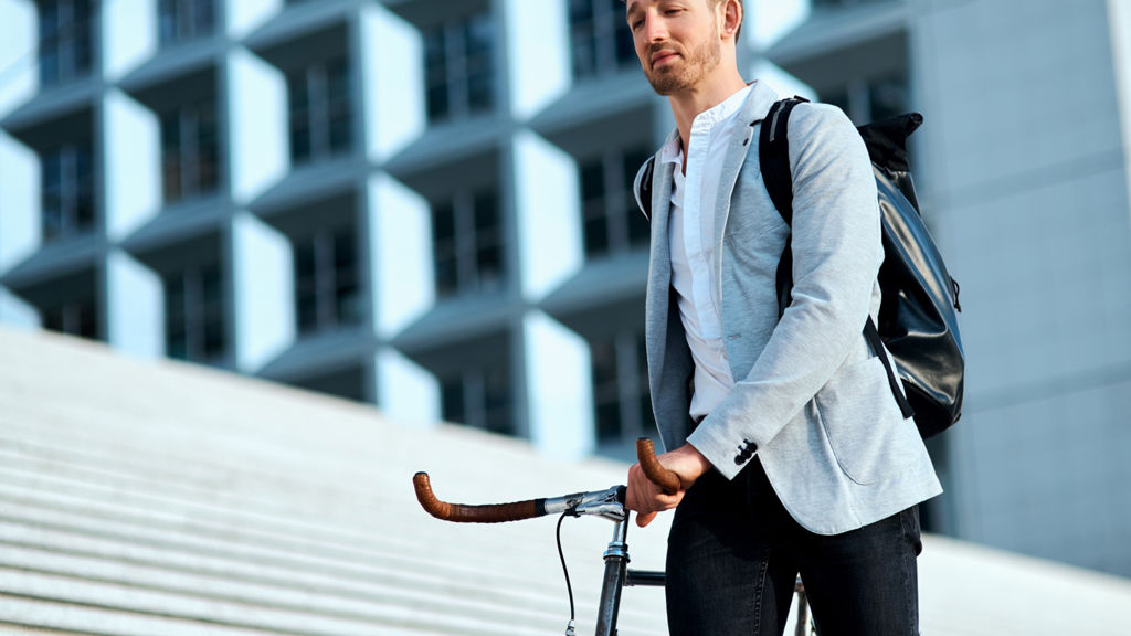 mand holder sin cykel foran arbejdsplads