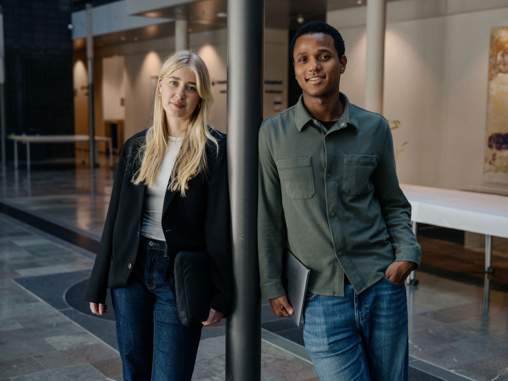 to unge studerende stå og smiler