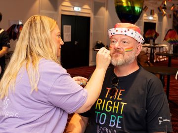 Pride billede, mand bliver malet med ansigtsmaling af kvinde