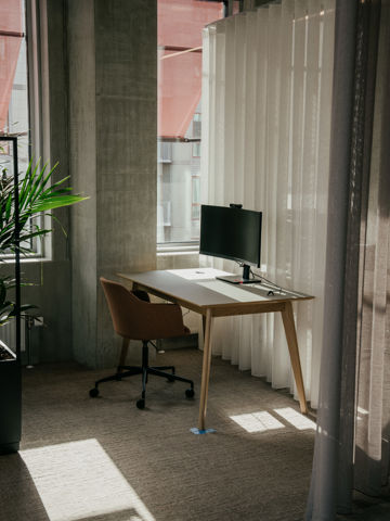 Skrivebord med skærm og stol i AL Huset