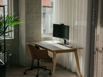 Skrivebord med skærm og stol i AL Huset