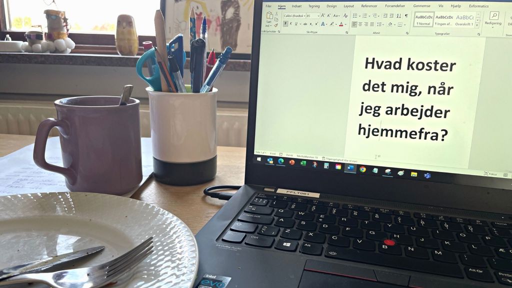 Skrivebord med computer og tom tallerken