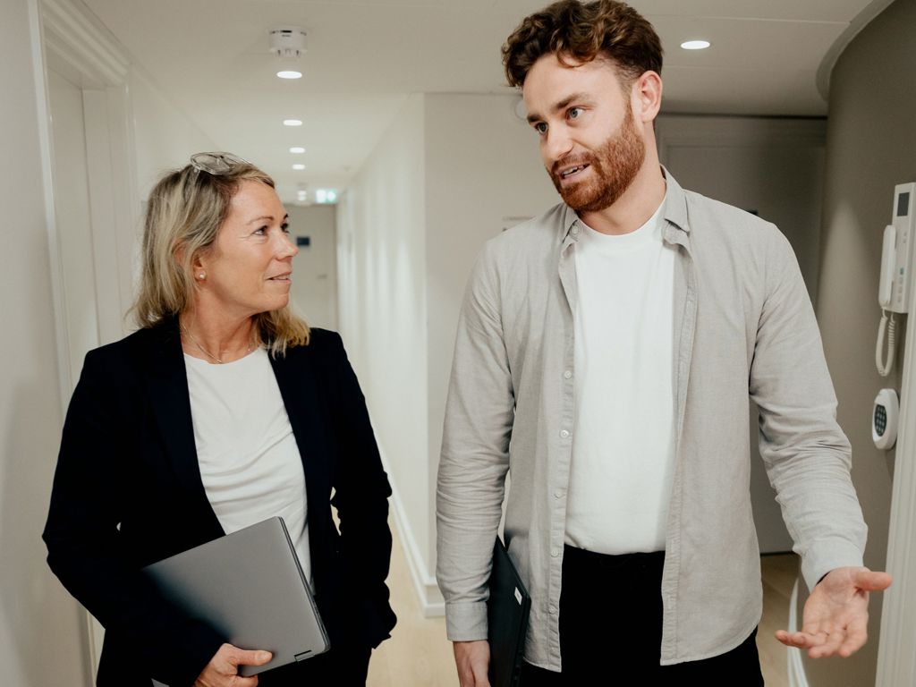 Mand og kvinde går ned ad gang og taler sammen