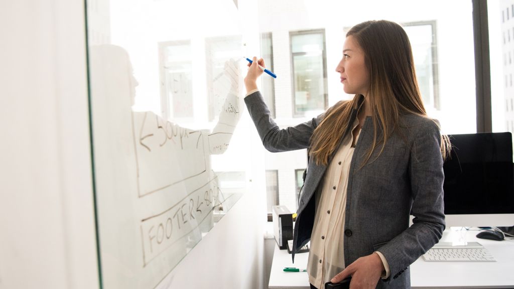 kvinde skriver på whiteboard