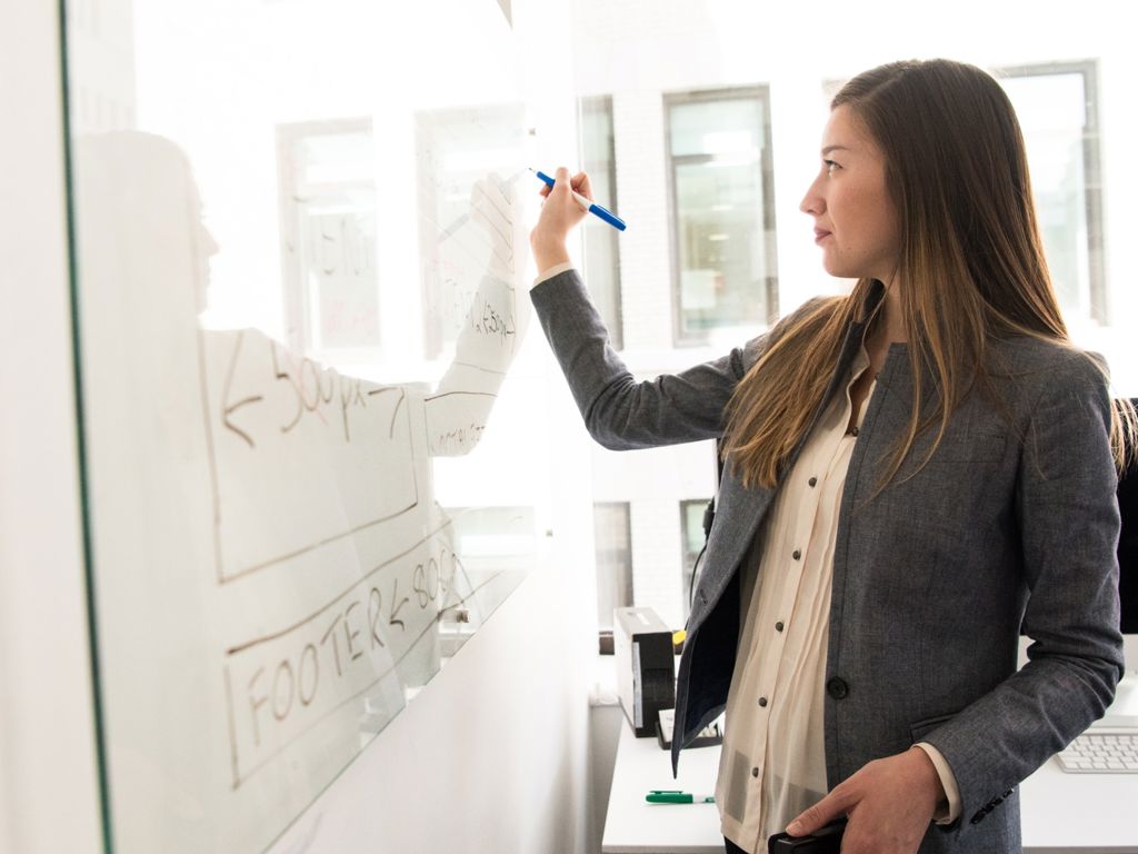 kvinde skriver på whiteboard