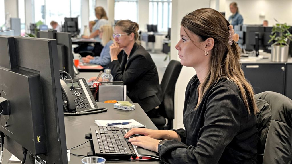 Ung kvinde sidder ved pc i Sydbank