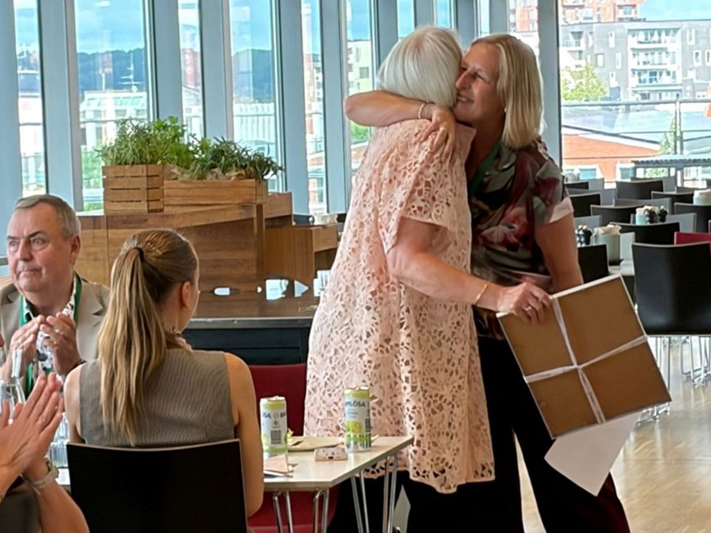 Marianne Lillevang får et knus af formand for Finansforbundet Dorrit Brandt mens tre mennesker klapper