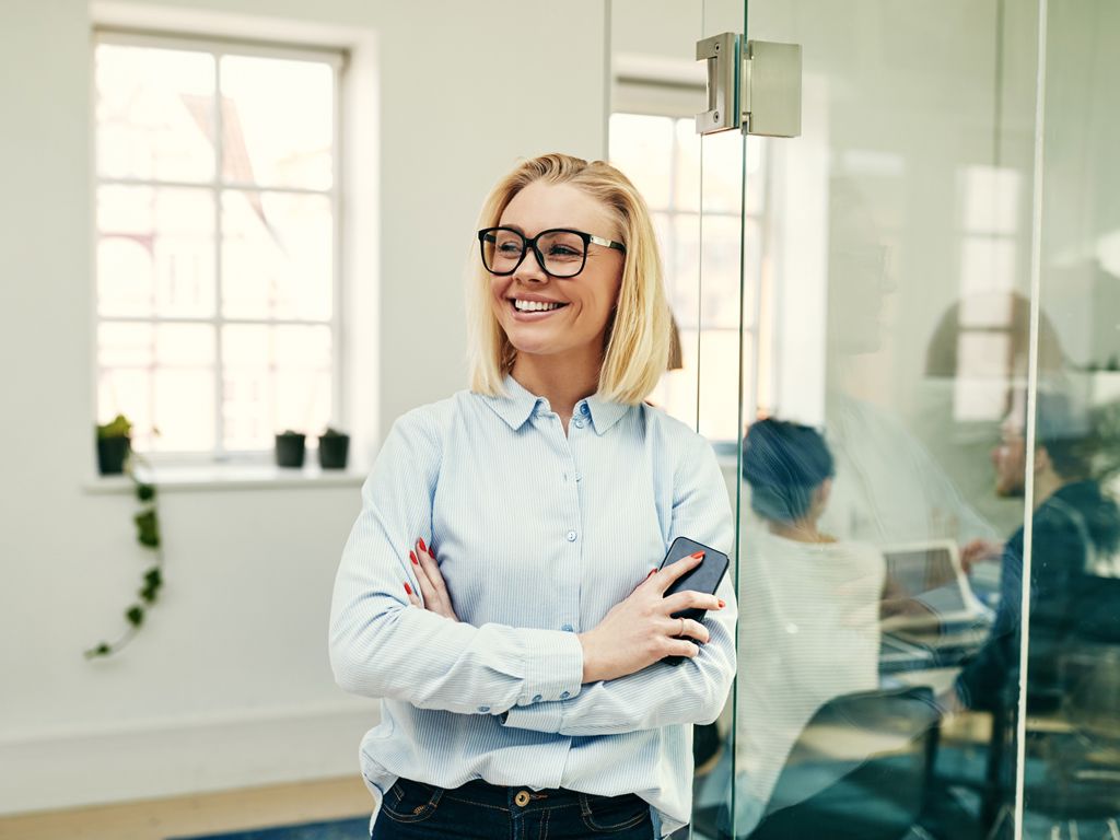 en kvinde smiler på et kontor