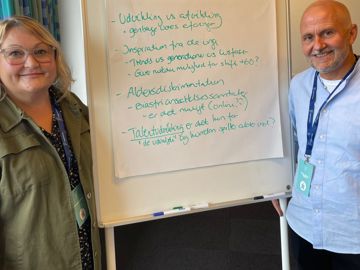 To netværksdeltagere ved en whitborad tavle