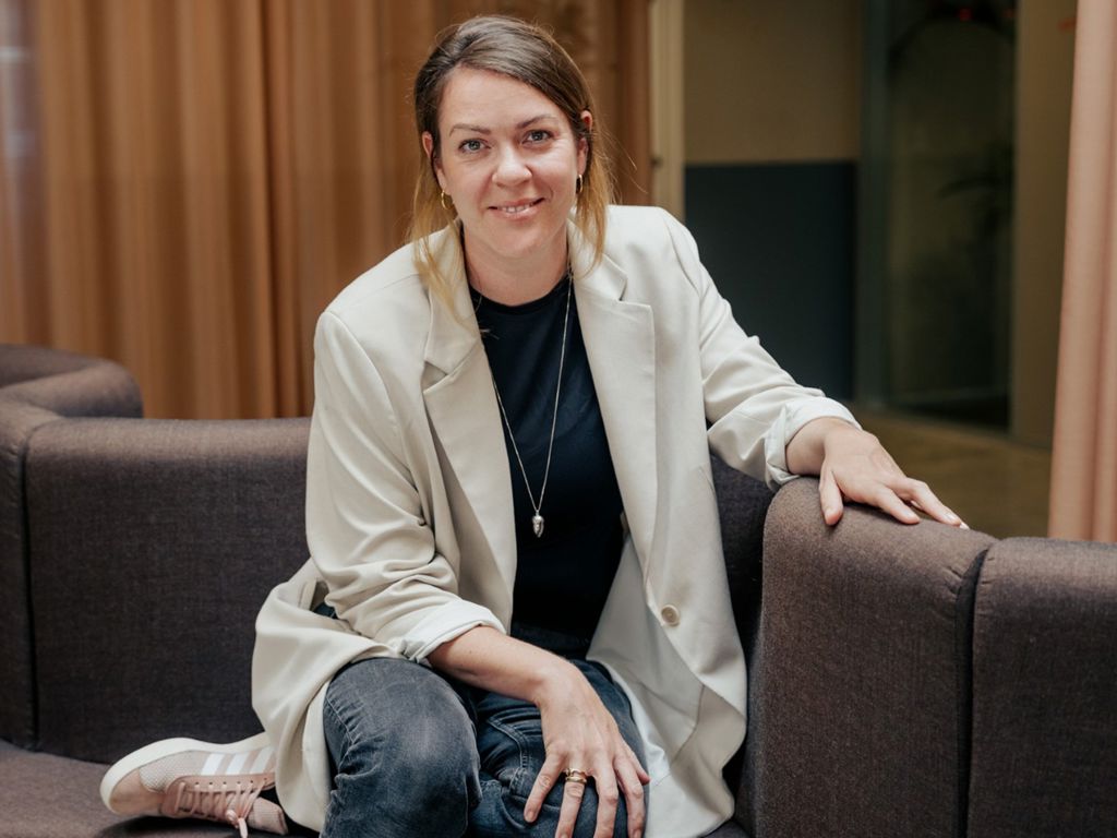Nynne som er TR sidder i en sofa