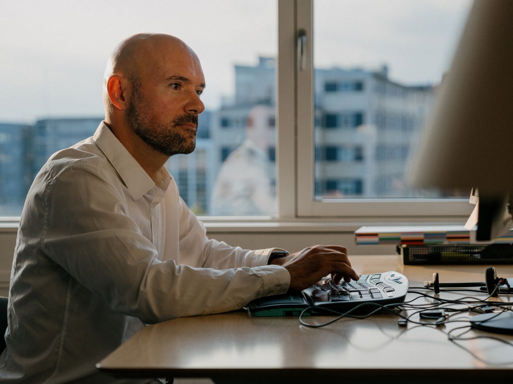 mand sidder ved computer og arbejder