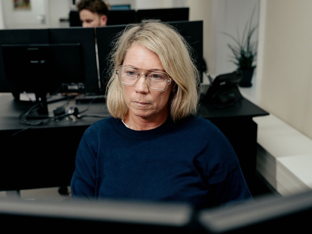 Kvindelig ansat bag computer på storrumskontor